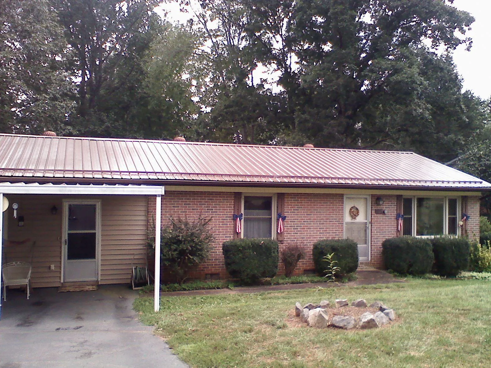 Bronze metal roof and carport on a brick ranch home — Roof Repair work by our crew in Saint Cloud